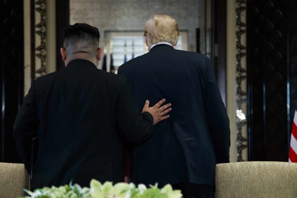 President Donald Trump and North Korean leader Kim Jong Un participate in a signing ceremony during a meeting on Sentosa Island, Tuesday, June 12, 2018, in Singapore. (Evan Vucci/AP)