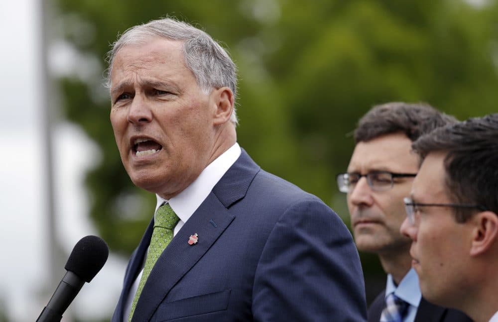 Washington Gov. Jay Inslee, left, speaks as Attorney General Bob Ferguson, center, and Solicitor General Noah Purcell look on at a news conference announcing a lawsuit against the Trump administration over a policy of separating immigrant families illegally entering the United States, in front of the Federal Detention Center Thursday, June 21, 2018, in SeaTac, Wash. Ferguson made the announcement outside the federal prison south of Seattle, where about 200 immigration detainees have been transferred — including dozens of women separated from their children under the administration's &quot;zero-tolerance&quot; policy. (Elaine Thompson/AP)