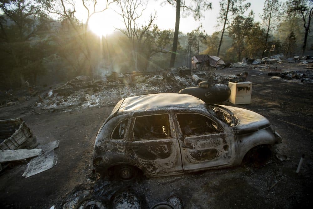 A vehicle scorched by a wildfire rests in a clearing on Wolf Creek Road near Clearlake Oaks, Calif., Sunday, June 24, 2018. Wind-driven wildfires destroyed buildings and threatened hundreds of others Sunday as they raced across dry brush in rural Northern California. (Noah Berger/AP)