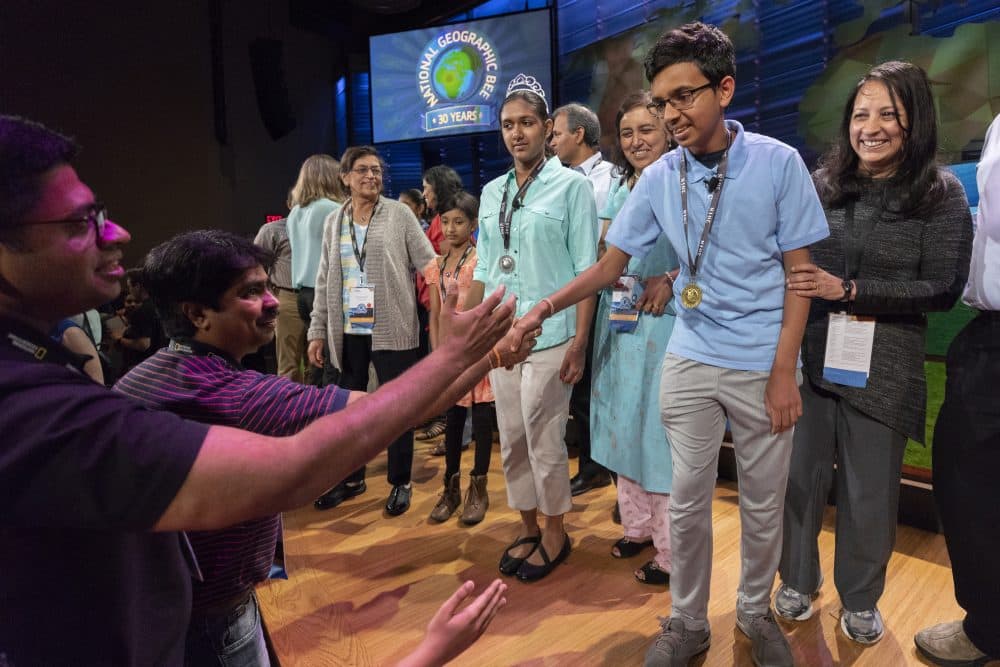 2018 National Geographic Bee Champion Venkat Ranjan of California shakes hands with audience members after the final competition in Washington, D.C., on May 23. Also pictured on stage is second-place finisher Anoushka Buddhikot of New Jersey. (Mark Thiessen/National Geographic)