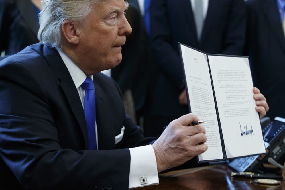 President Donald Trump shows off his signature on an executive order about the Dakota Access pipeline, Tuesday, Jan. 24, 2017, in the Oval Office of the White House in Washington. (Evan Vucci/AP)