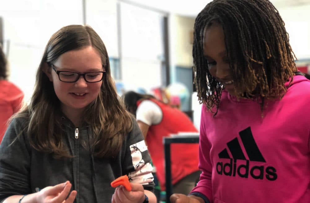 Fifth graders Charlotte Groth, left, and Zoe Gillispie work on their capstone project at the Curley K-8 School in Jamaica Plain. (Max Larkin/WBUR)