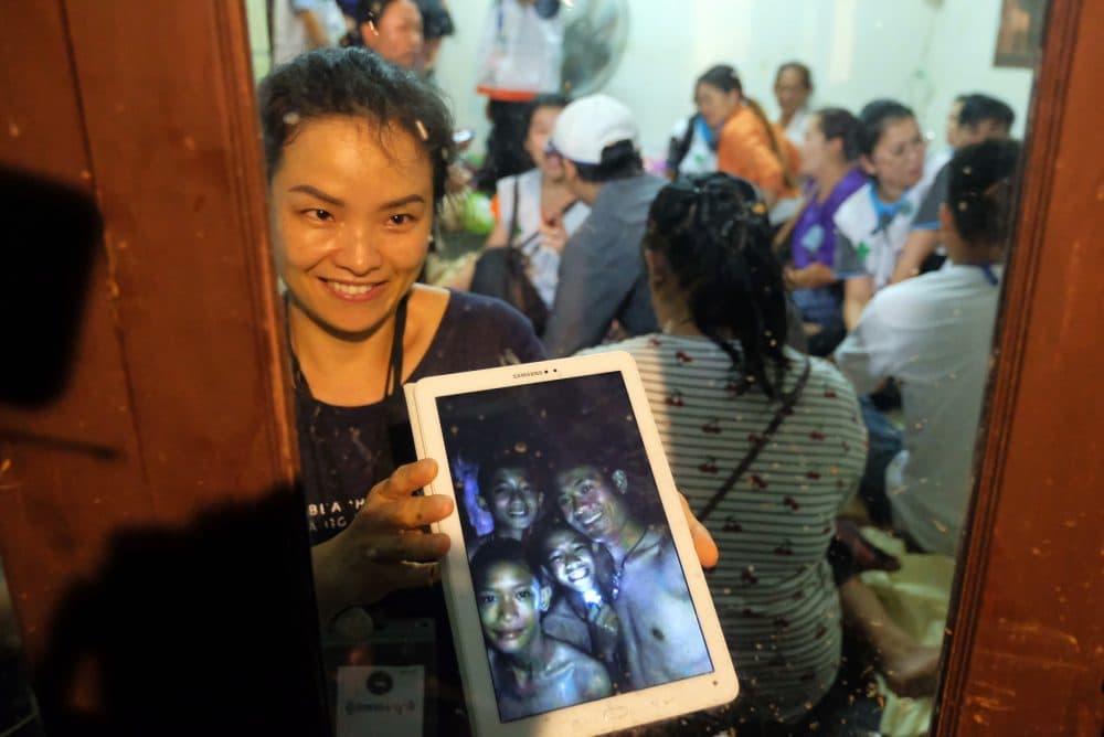 Relatives of the missing boys show photos of them after the 12 boys and their soccer coach were found alive in the cave where they've been missing for over a week after monsoon rains blocked the main entrance on July 2, 2018 in Chiang Rai, Thailand. (Linh Pham/Getty Images)