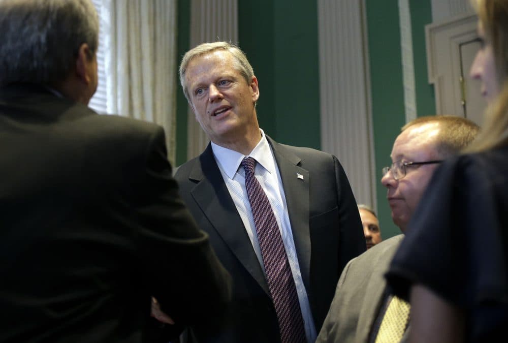 Republican Gov. Charlie Baker, center, shakes hands at the conclusion of a bill signing ceremony Wednesday at the State House in Boston. (Steven Senne/AP)