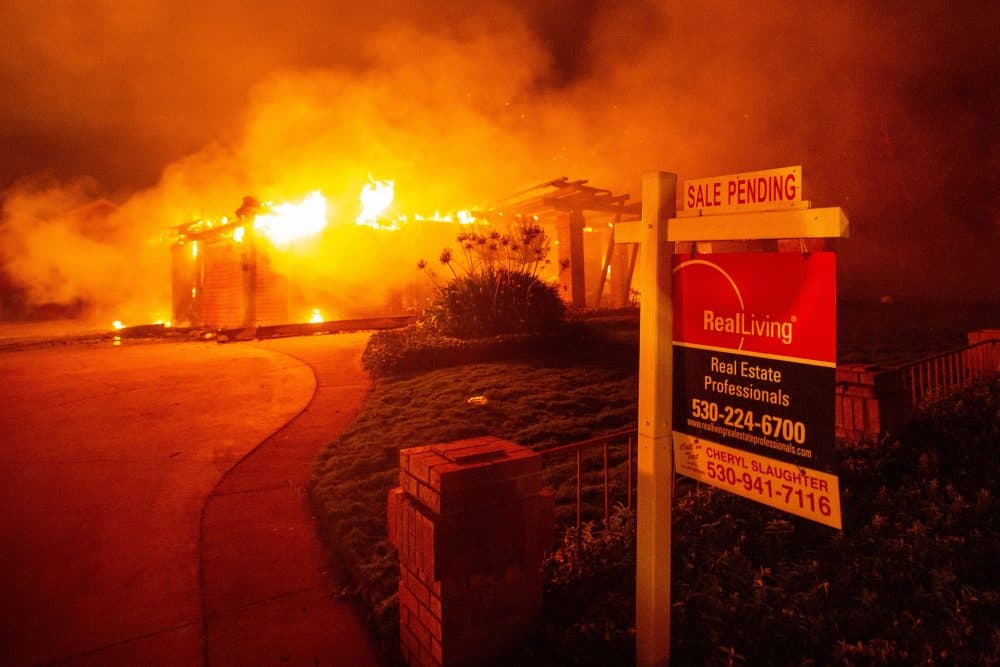 A real estate sign is seen in front of a burning home during the Carr Fire in Redding, Calif., on July 27, 2018. (Josh Edelson/AFP/Getty Images)