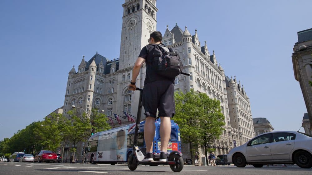 A man rides an electric-scooter-sharing from a company called the 'Bird' along Pennsylvania Ave., in front of the Trump International Hotel in downtown Washington on May 14. (Pablo Martinez Monsivais/AP)