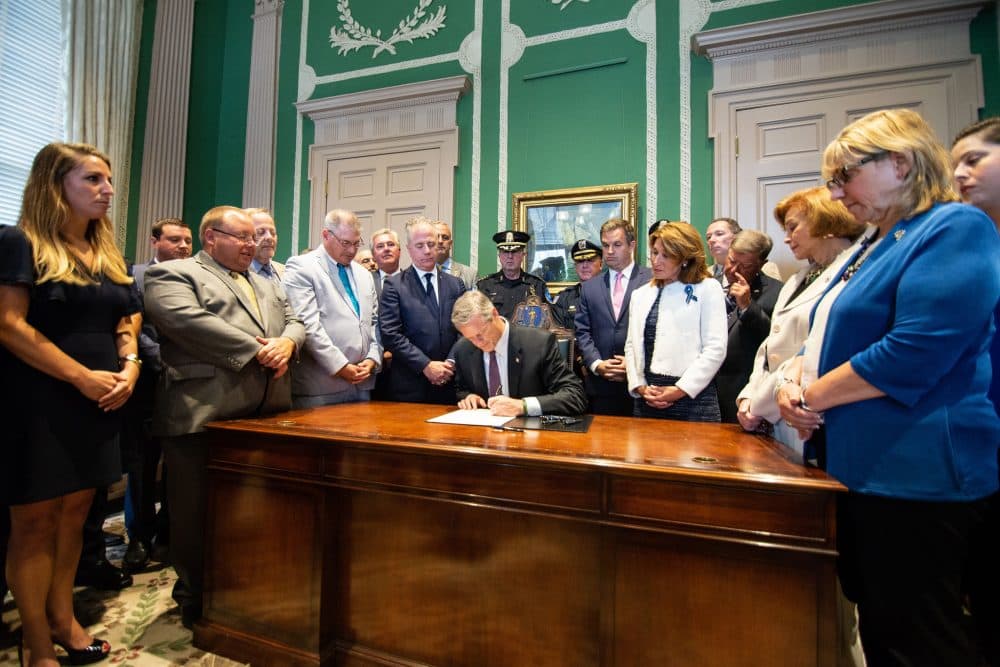 Gov. Charlie Baker guaranteed benefits for locked-out gas workers today. Here, he signs H. 4516, relative to the municipal police training fund, in July. (Courtesy of Josephine Pettigrew for the Office of the Governor)