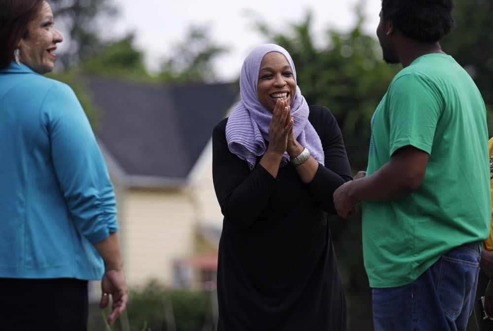 Attorney Tahirah Amatul-Wadud, who is challenging incumbent U.S. Rep. Richard Neal, D-Mass., center, talks with Dondre Scott, right, during a visit to a community garden while campaigning in the Mason Square neighborhood of Springfield, Mass. Monday, June 18, 2018. At left is Ivette Hernandez, who is running for Mass. House of Representatives. (Charles Krupa/AP)