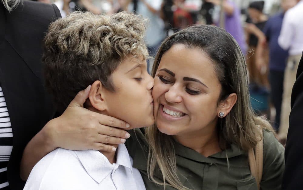 Diego Magalhaes, left, 10, kisses his mother Sirley Silveira Paixao, an immigrant from Brazil seeking asylum with her son, after Diego was released from immigration detention Thursday in Chicago. (Charles Rex Arbogast/AP)