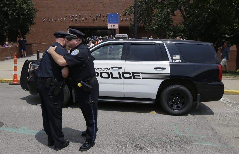 Two Weymouth, Mass. police officers embrace outside district court, in Quincy, Mass. before the scheduled arraignment of Emanuel Lopes, Tuesday, July 17, 2018. Lopes is accused of fatally shooting Weymouth police officer Michael Chesna and an innocent bystander, 77-year-old Vera Adams, Sunday, July 15, 2018. (Steven Senne/AP)