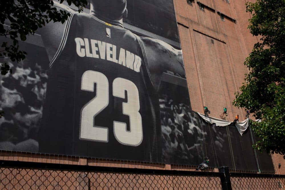 Workers take down the LeBron James banner from Cleveland's Sherwin Williams building. James is on his way to Los Angeles. (Photo by Angelo Merendino/Getty Images)
