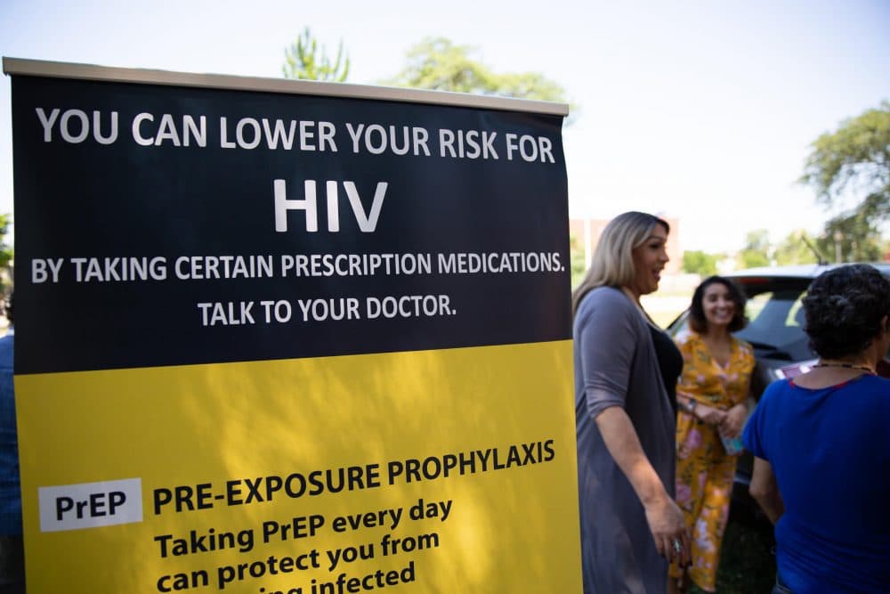 Tatiana Melendez, standing tall next to the PrEP promotional poster, does HIV prevention outreach at Hartford's Barnard Park on a recent Friday. (Ryan Caron King/NENC)