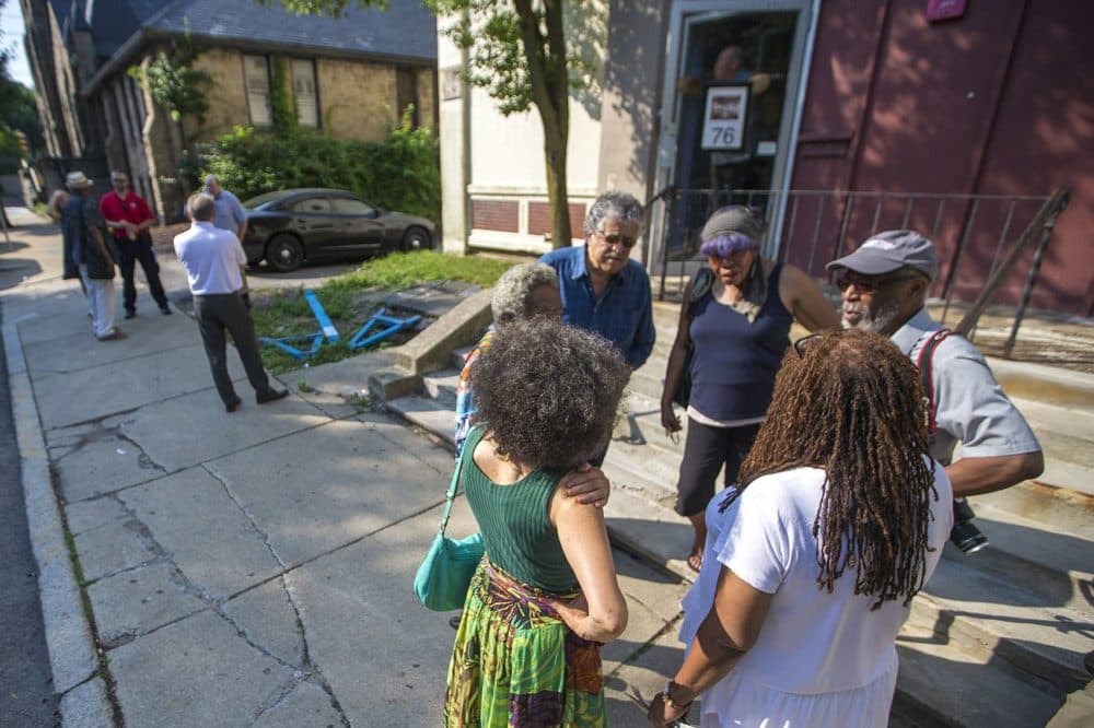 Members of the African-American Master Artists-in-Residence Program (AAMARP) gather outside the 76 Atherton St. warehouse after Northeastern University's original notice to vacate. (Jesse Costa/WBUR)