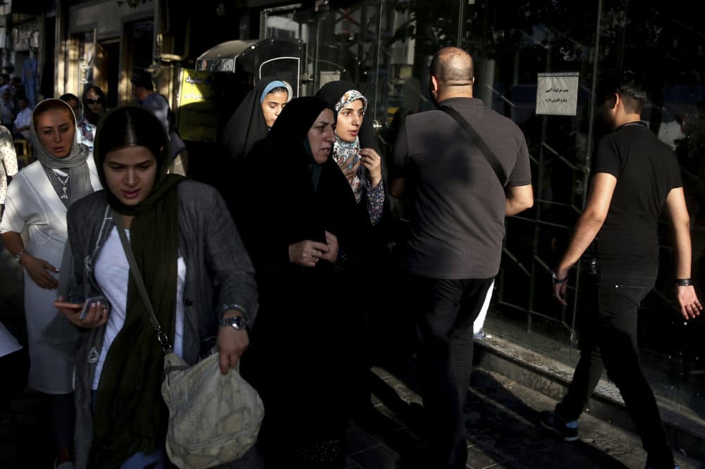 People make their way on a sidewalk in downtown Tehran, Iran, Monday, July 30, 2018. Iran's currency has dropped to a record low ahead of the imposition of renewed American sanctions, with many fearing prolonged economic suffering or possible civil unrest. (Ebrahim Noroozi/AP)