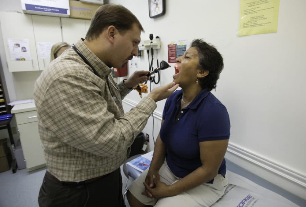 Dr. Javier Hiriart, left, examines a patient during a medical checkup at Camillus Health Concern in Miami on Sept. 8, 2009.(Lynne Sladky/AP)