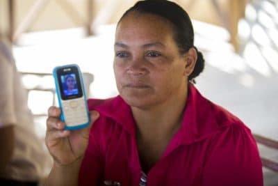Rosa Lina Linder shows a photograph of her 16-year-old daughter on her cellphone, still being detained in the U.S. (Jesse Costa/WBUR)