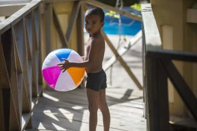 Six-year-old Hector Galvez carries a beach ball on his way to the pool in La Ceiba, Honduras. (Jesse Costa/WBUR)