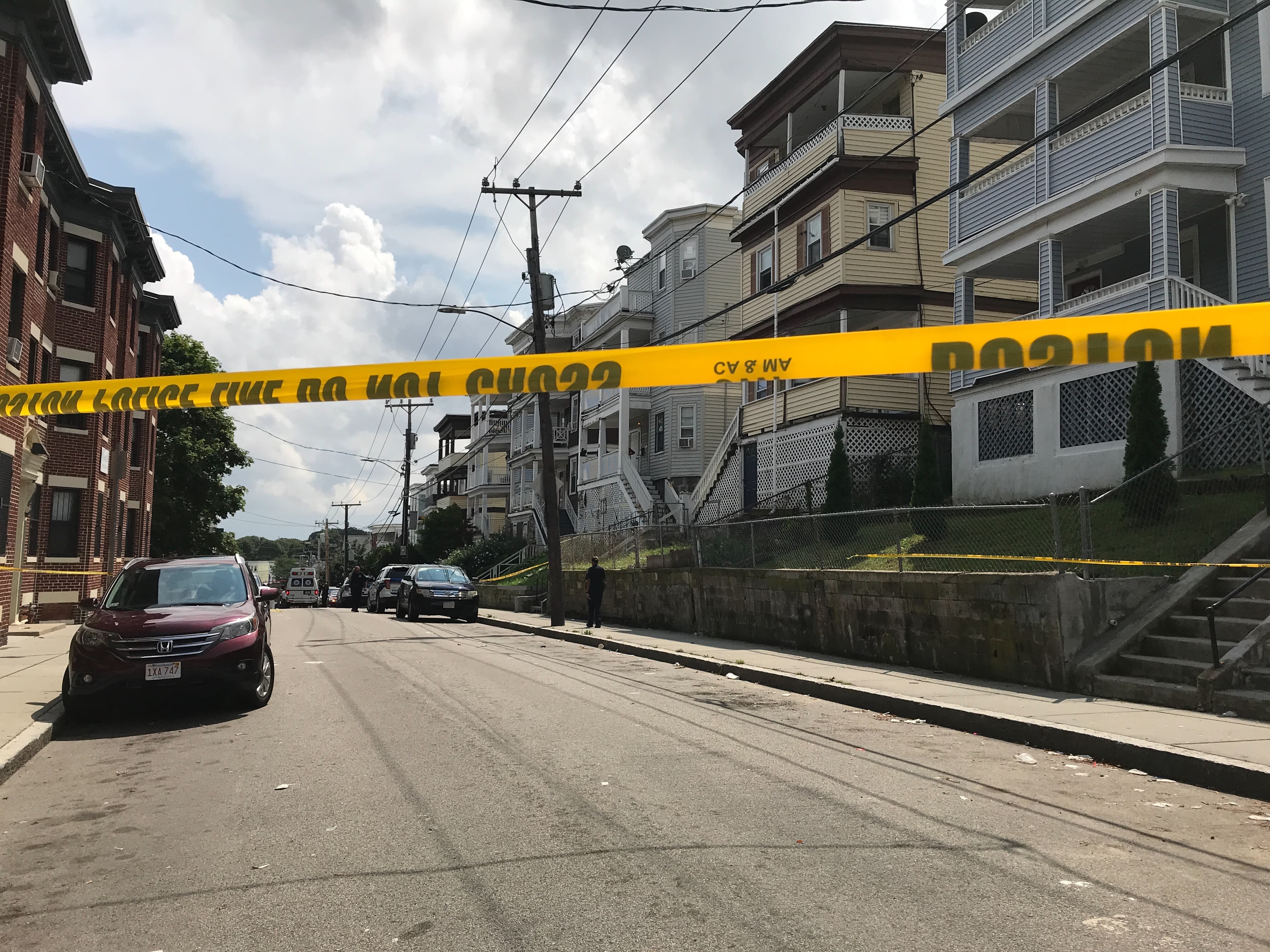 Police tape runs across Deering Road, where a fatal shooting left one young man dead and two others injured. (Quincy Walters/WBUR)