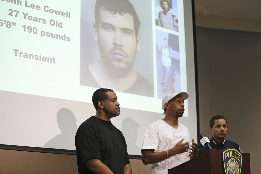 Daryle Allums, center, speaks on behalf of the Stop Killing Our Kids movement, about the stabbing of his goddaughter at a press conference Monday, July 23, 2018 in Oakland, Calif., as Bay Area Rapid Transit Police Chief Carlos Rojas, right, and Daryle Muhammad, left, listen. The suspect in the stabbing, John Lee Cowell, 27, is seen projected in the background. A man fatally stabbed an 18-year-old woman in the neck and wounded her sister as they exited a train at a Northern California subway station in what officials said Monday appeared to be a random attack. The suspect attacked the sisters Sunday night as they left a train at the Bay Area Rapid Transit's MacArthur Station in Oakland. (Lorin Eleni Gill/AP)