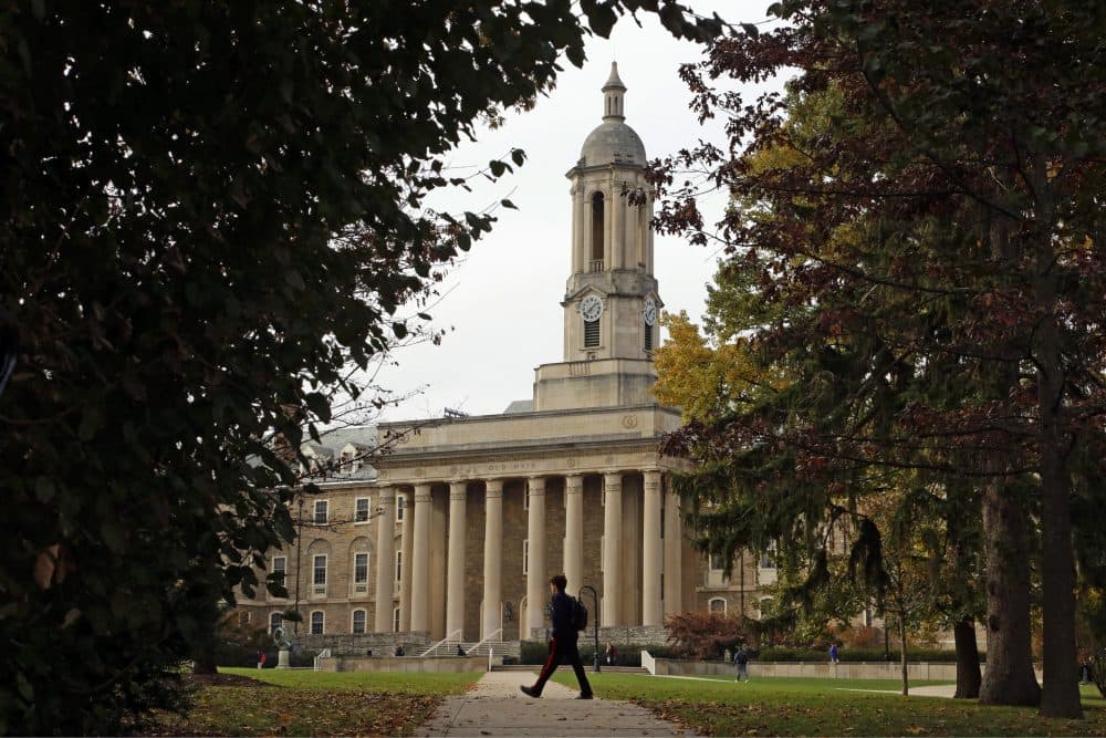 In this Nov. 9, 2017, file photo people walk by Old Main on the Penn State University main campus in State College, Penn.(Gene J. Puskar, File/AP)