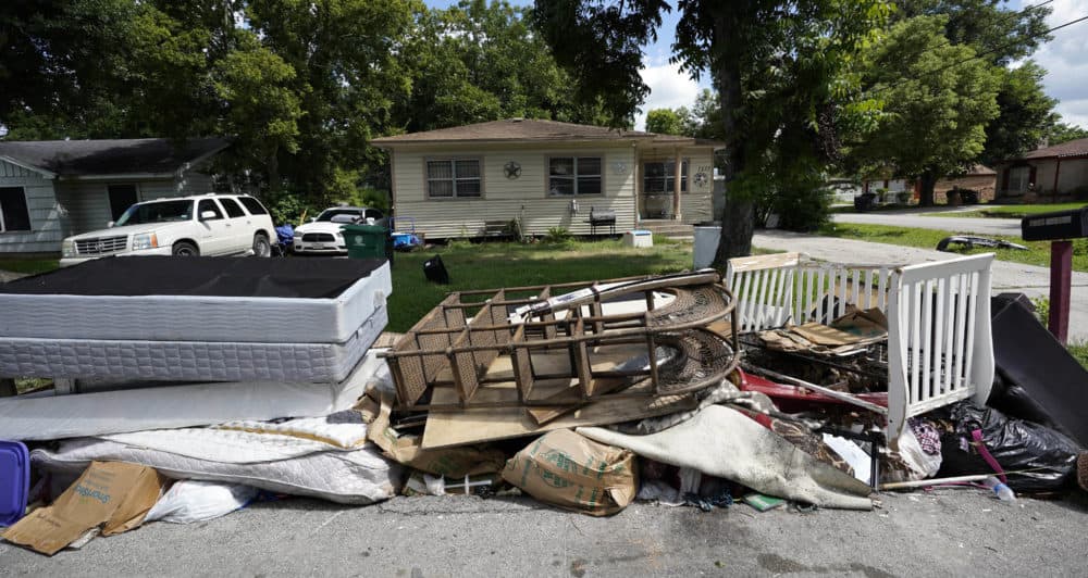 In this Aug. 9, 2018 photo, recently removed flood-damaged debris sits outside a home in Houston. Hurricane Harvey has been described as the storm that did not discriminate, damaging neighborhoods both rich and poor. But community and grassroots leaders say that a year after the storm, those having the hardest time recovering are residents who live in some of the poorest areas hit hardest by Harvey. (David J. Phillip/AP)