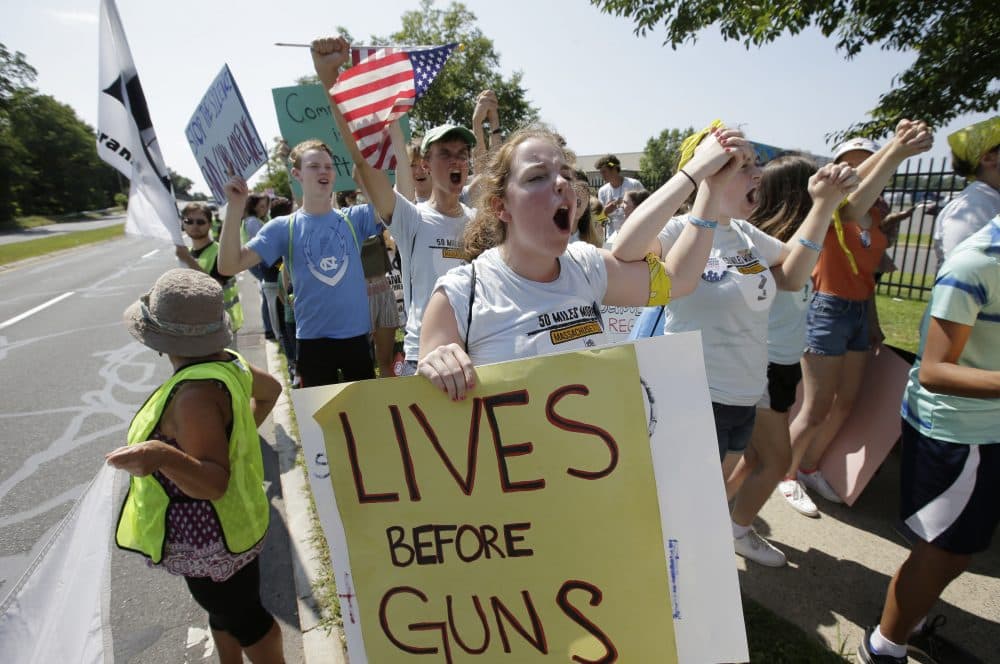 Chloe Carr, 18, of Natick, front, chants slogans during the final mile of a 50-mile march. The march, held to call for gun law reforms, began in Worcester and ended in Springfield, with a rally near the headquarters of gun manufacturer Smith & Wesson. (Steven Senne/AP)