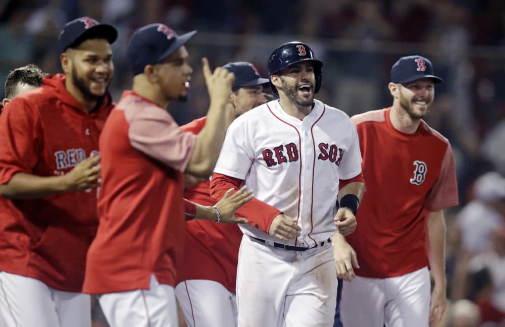 Boston Red Sox's J.D. Martinez, second from right, celebrates with teammates after scoring after Eduardo Nunez reached first base on a throwing error, breaking a 7-7 tie, during the bottom of the ninth inning of a baseball game at Fenway Park in Boston, Tuesday, Aug. 28, 2018. The Red Sox won 8-7. (Charles Krupa/AP)