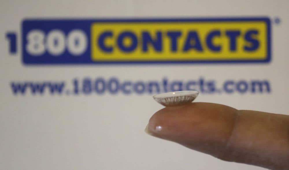 A contact lens is shown in front of a 1-800-Contacts shipping box Wednesday, May 13, 2015, in Salt Lake City. (Rick Bowmer/AP)