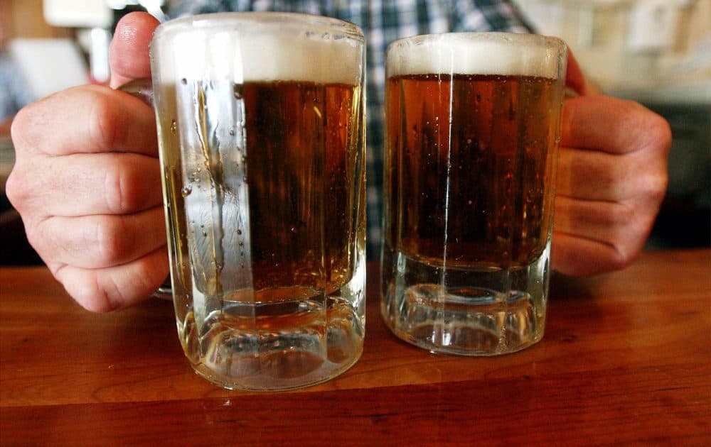 A bartender serves two mugs of beer at a tavern in Montpelier, Vermont. (Toby Talbot/AP)