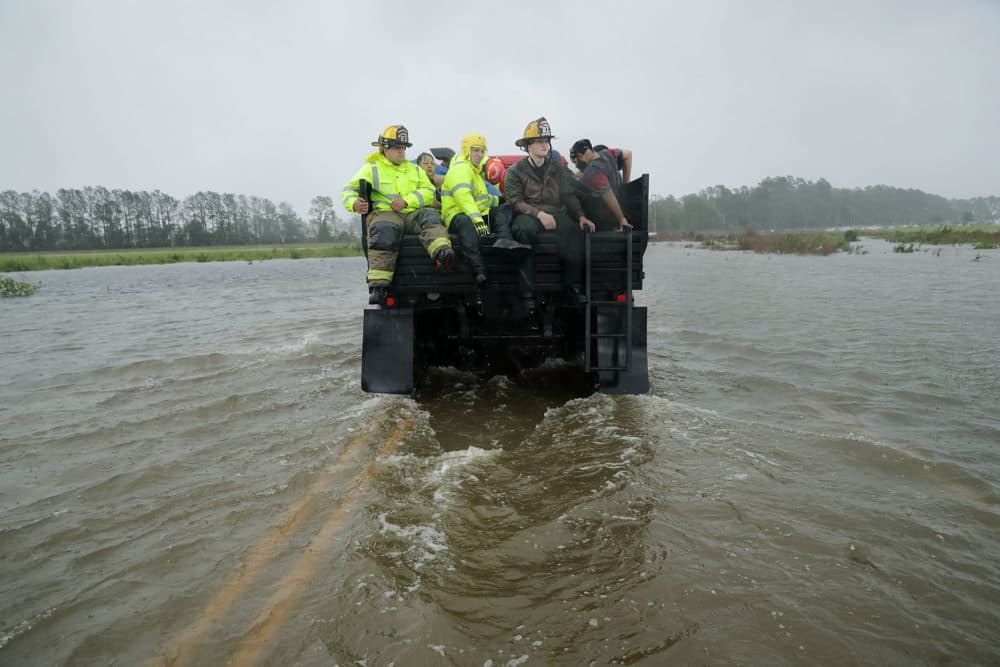 Rescue workers from the Township No. 7 Fire Department and volunteers from the Civilian Crisis Response Team use a truck to move people rescued from their flooded homes during Hurricane Florence on Sept. 14, 2018 in James City, N.C. (Chip Somodevilla/Getty Images)