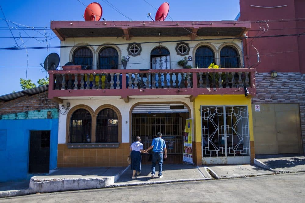A couple walk hand-in-hand into Panaderia Pacita Quintanilla in San Vicente, El Salvador. (Jesse Costa/WBUR)