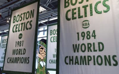 Lucky the Leprechaun, the Boston Celtics team logo, peers out from in between Celtics championship banners hanging in their new basketball team practice facility. (Elise Amendola/AP)