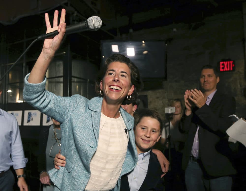 Incumbent Democratic Rhode Island Gov. Gina Raimondo waves to supporters alongside her son, Thompson, at her primary night victory party Wednesday in Providence, R.I. (Elise Amendola/AP)