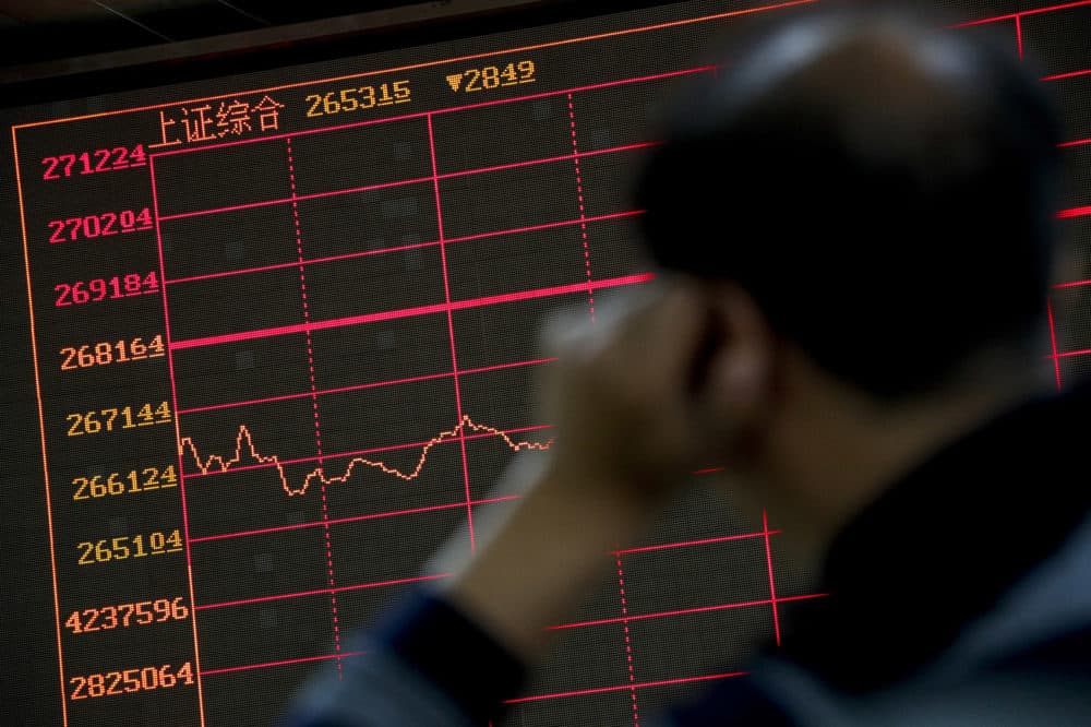 An investor monitors shares prices in front of an electronic board displaying the Shanghai Composite index at a brokerage house in Beijing, Monday, Sept. 17, 2018. Asian shares were mostly lower Monday on reports that President Donald Trump will soon place tariffs on $200 billion more of Chinese goods, even as officials worked to iron out tensions between the world's two largest economies. (AP Photo/Andy Wong)