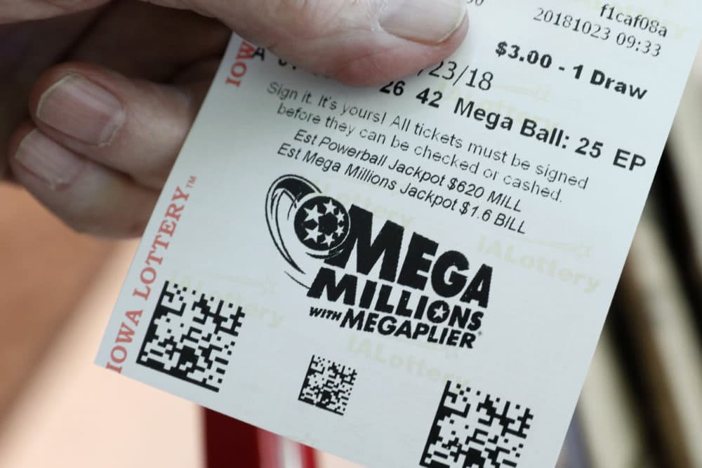 A customer shows his Mega Millions lottery ticket at a local grocery store on Tuesday in Des Moines, Iowa. (Charlie Neibergall/AP)