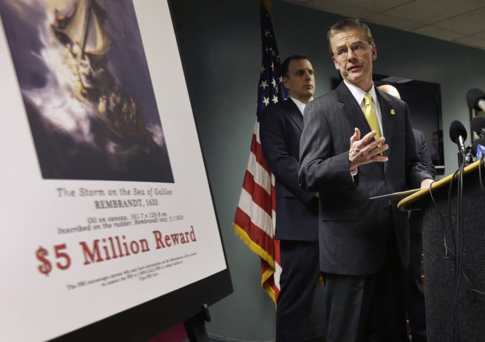 FBI Special Agent in Charge Richard DesLauriers stands next to a poster that shows a Rembrandt painting during a press conference on March 18, 2013. (Steven Senne/AP)