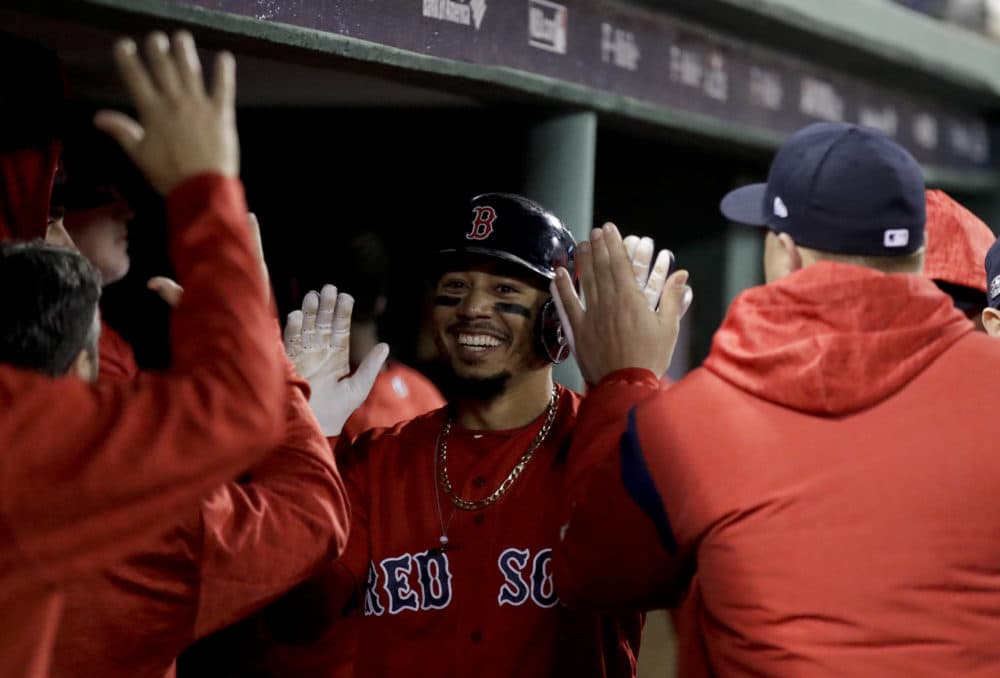 Boston Red Sox's Mookie Betts celebrates in the dugout after scoring of a single by Steve Pearce during the third inning of Game 1 of a baseball American League Division Series against the New York Yankees on Friday, Oct. 5, 2018, in Boston. (Charles Krupa/AP)