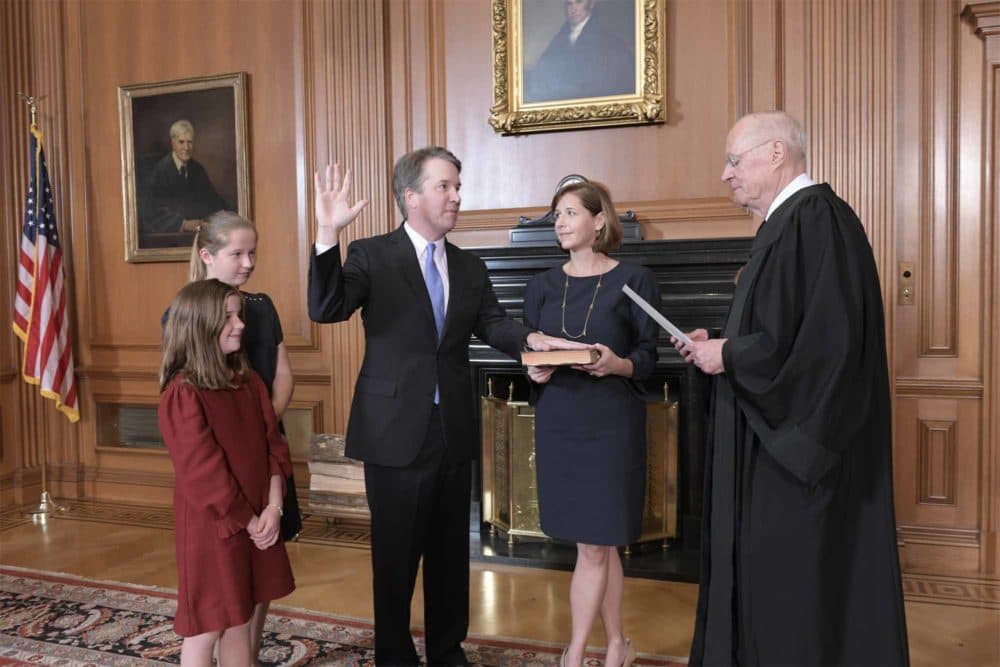 Retired Justice Anthony M. Kennedy, right, administers the Judicial Oath to Judge Brett Kavanaugh in the Justices' Conference Room of the Supreme Court Building. Ashley Kavanaugh holds the Bible. At left are their daughters, Margaret, background, and Liza. (Fred Schilling/Collection of the Supreme Court of the United States via AP)