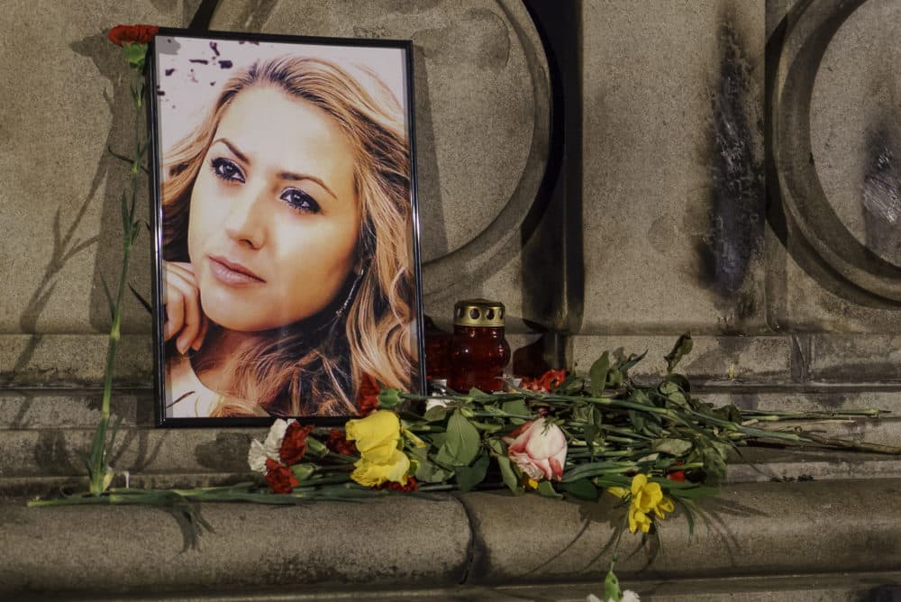 A portrait of slain television reporter Viktoria Marinova is placed on the Liberty Monument next to flowers and candles during a vigil in Ruse, Bulgaria, Tuesday, Oct. 9, 2018. (Filip Dvorski/AP)