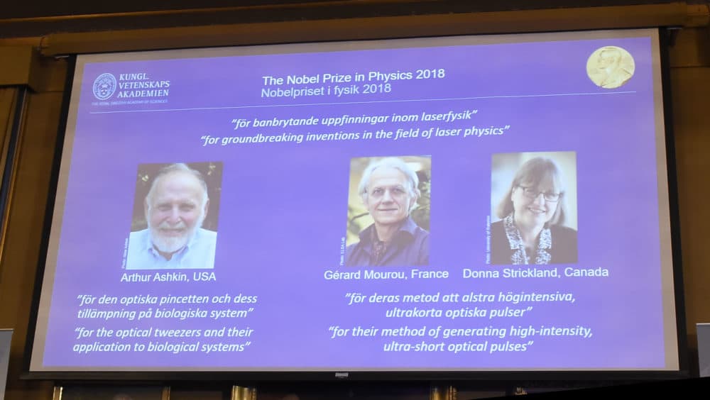 A screen displays portraits of Arthur Ashkin of the United States, Gerard Mourou of France and Donna Strickland of Canada during the announcement of the winners of the 2018 Nobel Prize in Physics at the Royal Swedish Academy of Sciences on Oct. 2, 2018 in Stockholm. (Hanna Franzen/AFP/Getty Images)