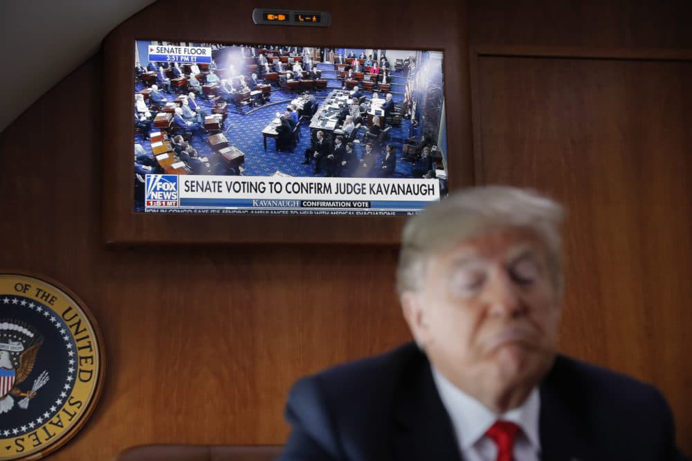 A live television broadcast of the Senate confirmation vote of Supreme Court nominee Brett Kavanaugh is displayed with President Donald Trump, on board Air Force One, Saturday, Oct. 6, 2018. Trump was traveling from Washington enroute to Topeka, Kan., for a campaign rally. (AP Photo/Pablo Martinez Monsivais)