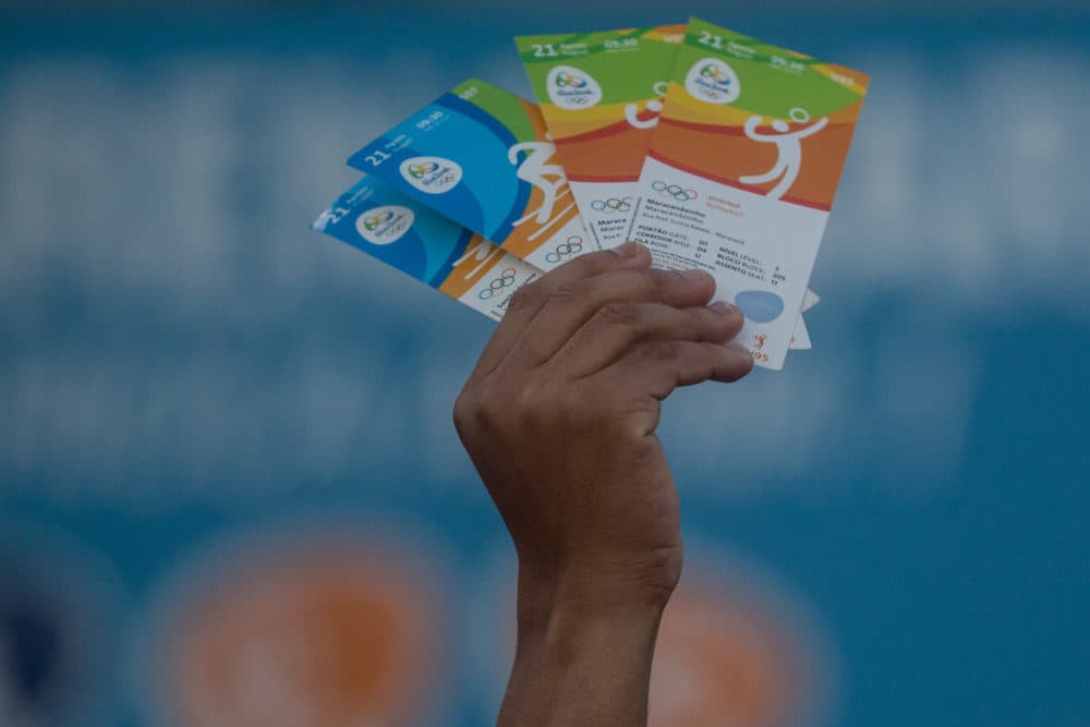 A man holds up tickets to sell or swap outside a venue at the Rio 2016 Olympic Games on Aug. 19, 2016 in Rio de Janeiro, Brazil. (Chris McGrath/Getty Images)