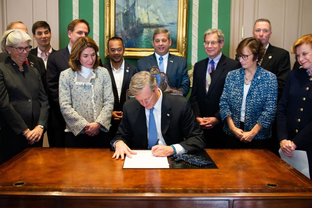Flanked by members of the Legislature, Gov. Charlie Baker on Thursday signed a bill to mandate civics education in Massachusetts public schools. (Courtesy governor's office)