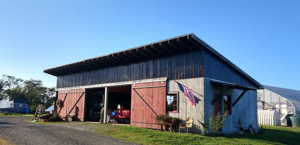 The Jamestown Community Farm's barn was built by local contractors who volunteered their time for the project. To the right, part of the greenhouse is visible along with tanks that store rain water. (Courtesy of Jon Kalish)