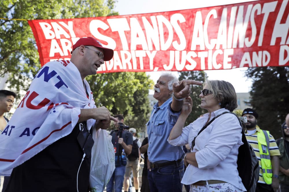 Donald Trump supporter Arthur Schaper, left, argues his position with Mustafa Payrvand, center, and Christina Tunnah during a free speech rally Sunday, Aug. 27, 2017, in Berkeley, Calif. Protesters gathered for a Rally Against Hate in response to a planned right-wing protest that raised concerns of clashes and prompted a large police presence. (AP Photo/Marcio Jose Sanchez)