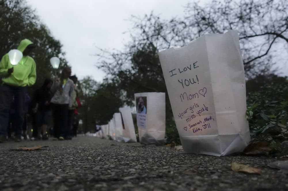 Participants pass bags decorated with messages for the deceased during an Out of the Darkness Walk event organized by the Cincinnati Chapter of the American Foundation for Suicide Prevention in Sawyer Point park, Sunday, Oct. 15, 2017, in Cincinnati. (John Minchillo/AP)