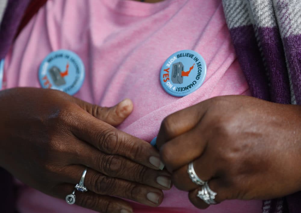 Yvette Demerit puts on a button in support of Amendment 4 at the Ben & Jerry's &quot;Yes on 4&quot; truck at Charles Hadley Park in Miami on Oct. 22, 2018. The amendment asking voters to restore voting rights to people with past felony convictions passed on election night. (Wilfredo Lee/AP)