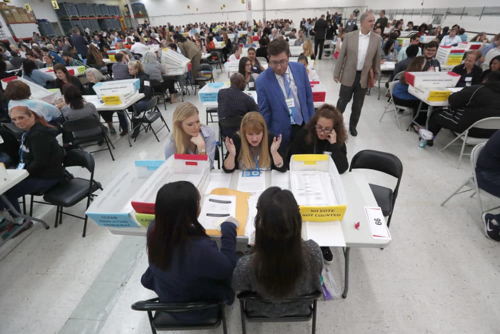 Workers at the Broward County Supervisor of Elections office show Republican and Democrat observers ballots during a hand recount, Friday, Nov. 16, 2018, in Lauderhill, Fla. (Wilfredo Lee/AP)