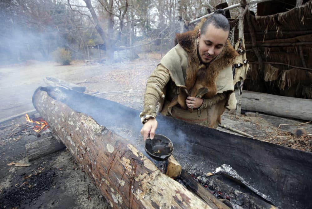 Mashpee Wampanoag Phillip Wynne, of Sagamore, Mass., pours water to control fire and temperatures while making a mishoon, a type of boat, from a tree at the Wampanoag Homesite at Plimoth Plantation, in Plymouth, Mass. Plymouth, where the Pilgrims came ashore in 1620, is gearing up for a 400th birthday, and everyone's invited, especially the native people whose ancestors wound up losing their land and their lives. (AP Photo/Steven Senne)