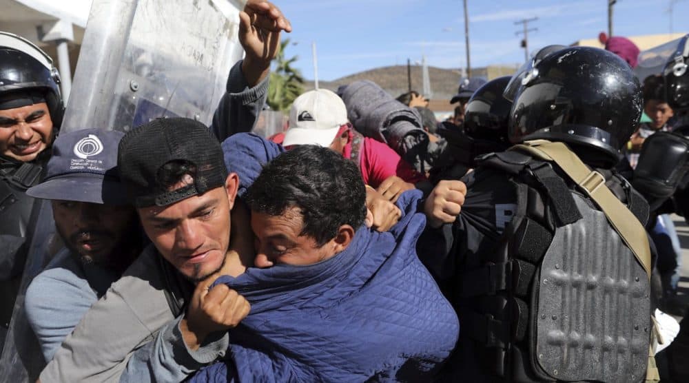Migrants clash with Mexican police at the Mexico-U.S. border after getting past another line of Mexican police at the Chaparral crossing in Tijuana, Mexico, Sunday, Nov. 25, 2018, as they try to reach the U.S. The mayor of Tijuana has declared a humanitarian crisis in his border city and says that he has asked the United Nations for aid to deal with the approximately 5,000 Central American migrants who have arrived in the city. (AP Photo/Rodrigo Abd)